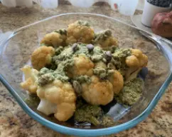 Step <p>Con cuidado, coloque la coliflor al vapor en una fuente de horno. Vierta el pesto sobre la coliflor y hornee durante 10 minutos (220°C). Retire del horno, espolvoree los pistachos restantes en trozos y sirva. </p> illustration