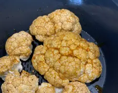 Step <p>Coloque un bol sobre la tapa del vaso, pese 40 g de aceite. Añada 2 cucharaditas de ajo en polvo, 1 cucharadita de pimentón, ¼ de cucharadita de pimienta de Cayena molida y 1 cucharadita de sal y mezcle bien con una cuchara. Pincele la superficie de la coliflor con la mezcla y colóquela en el recipiente Varoma. </p> illustration