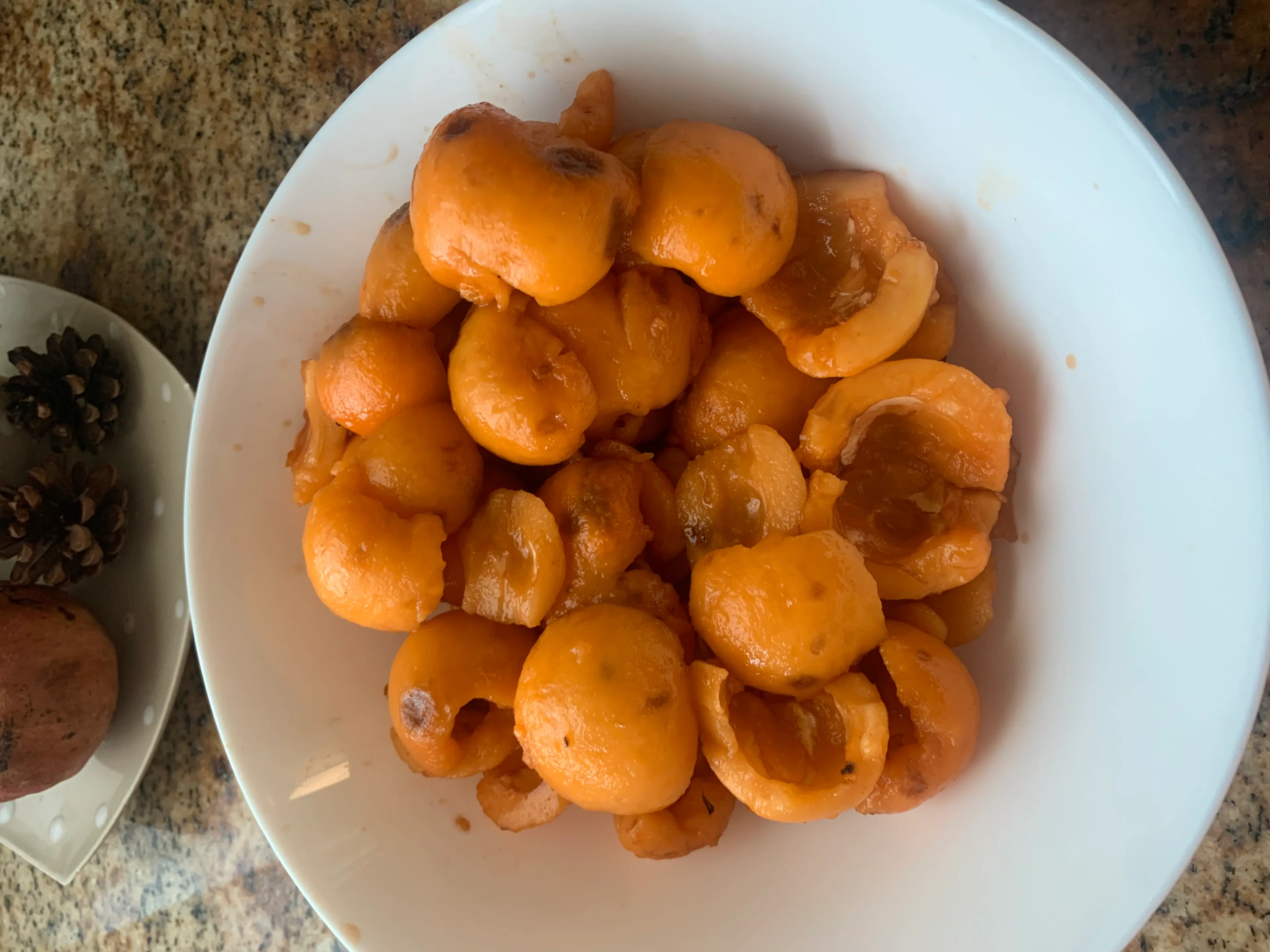 Step <p>Empezamos por lavar, pelar y deshuesar la fruta. Esto es lo que más trabajo lleva. Pelamos una naranja y la troceamos. Con la otra naranja hacemos zumo y previamente rallamos la piel de naranja que reservaremos.</p> illustration