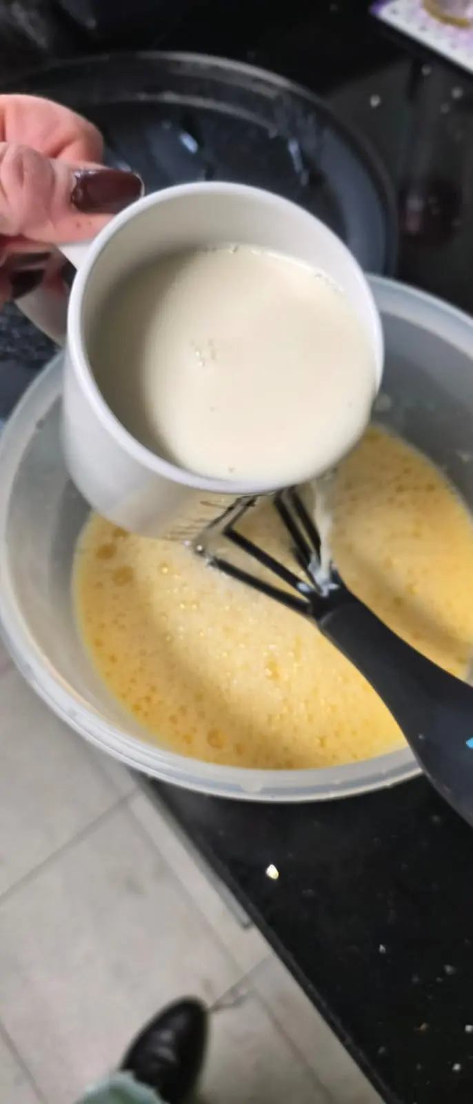 Step En otro bol rompe 3 yemas de huevo y mientras mueves con las varillas ve echando la leche, incorporándola toda. illustration